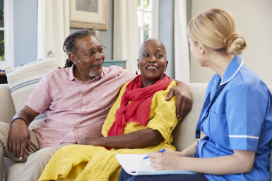 Nurse with couple on sofa