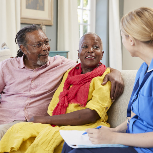 Nurse with couple on sofa
